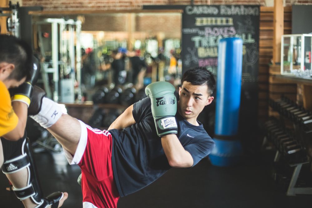 Strikers Inc. student landing a flying knee during Muay Thai training