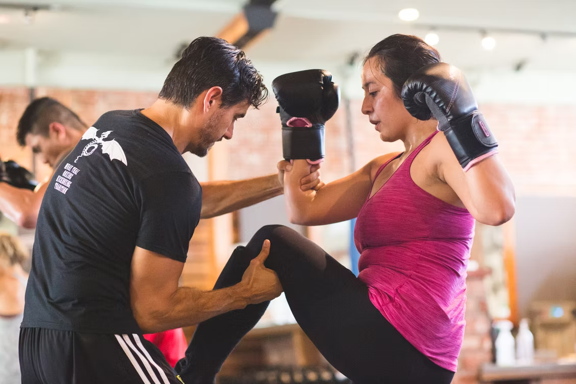 Coach Joe holding pads for a private one-on-one kickboxing session