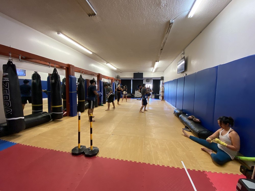 Inside the Strikers Inc. training floor with heavy bags in San Gabriel