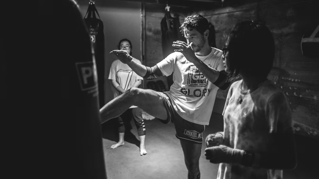 Coach Joe Del Real demonstrating a Muay Thai knee strike to students inside Strikers Inc. gym in San Gabriel